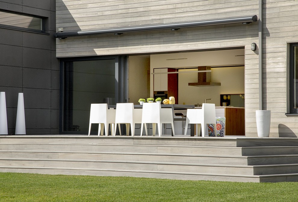 Источник вдохновения для домашнего уюта: большая терраса на заднем дворе в стиле модернизм с козырьком