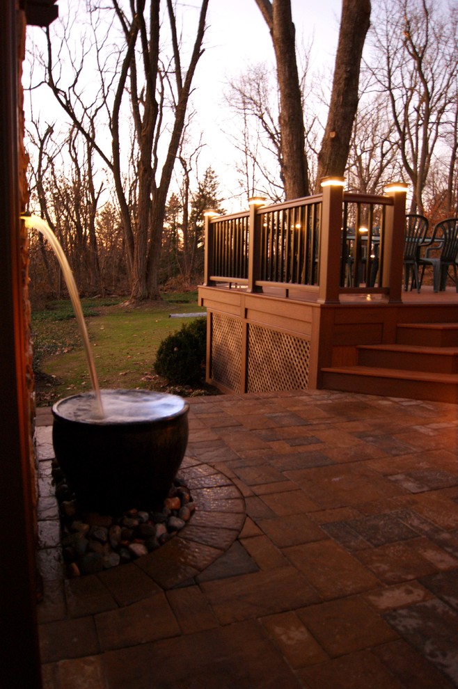 Exemple d'une terrasse arrière tendance de taille moyenne avec un point d'eau et une pergola.