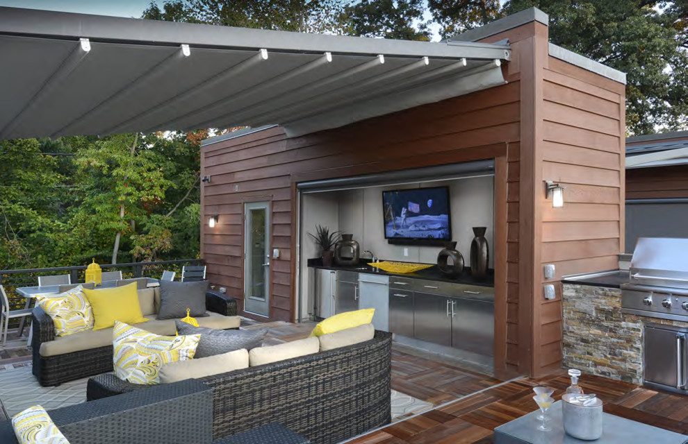 Trendy rooftop outdoor kitchen deck photo in DC Metro with a roof extension