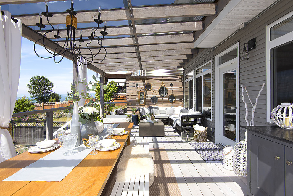 Réalisation d'une grande terrasse arrière méditerranéenne avec une cuisine d'été et un auvent.