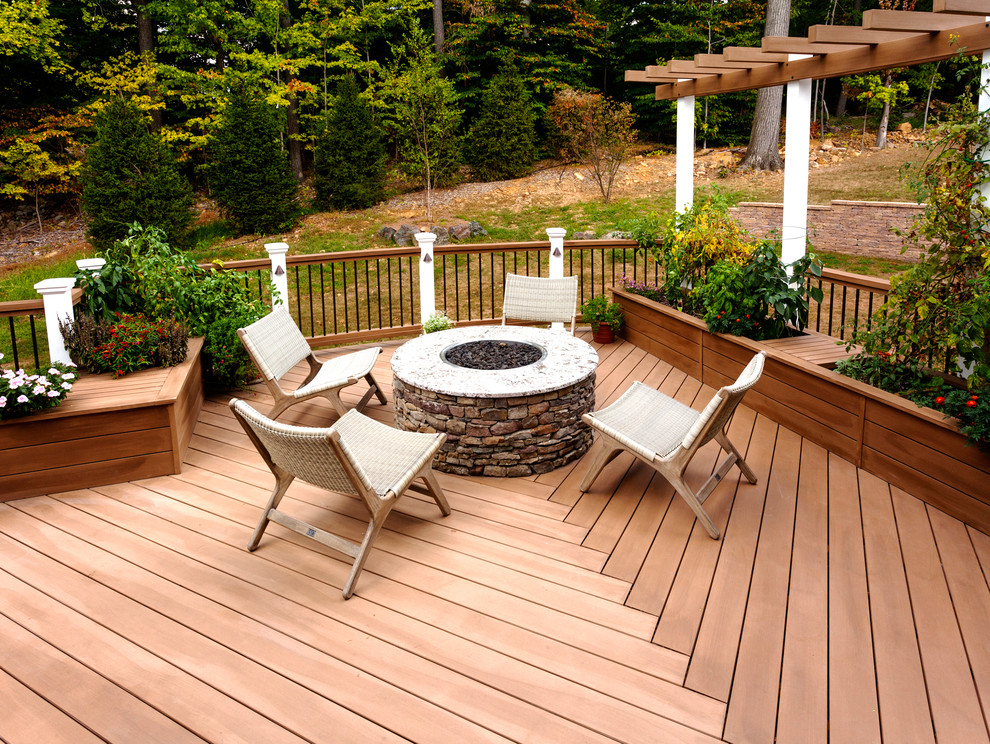 Cette image montre une grande terrasse arrière traditionnelle avec aucune couverture et un foyer extérieur.