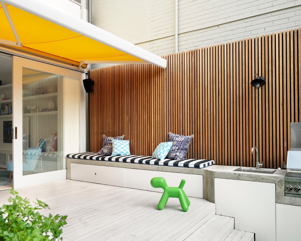 Esempio di una terrazza design di medie dimensioni e dietro casa con un parasole