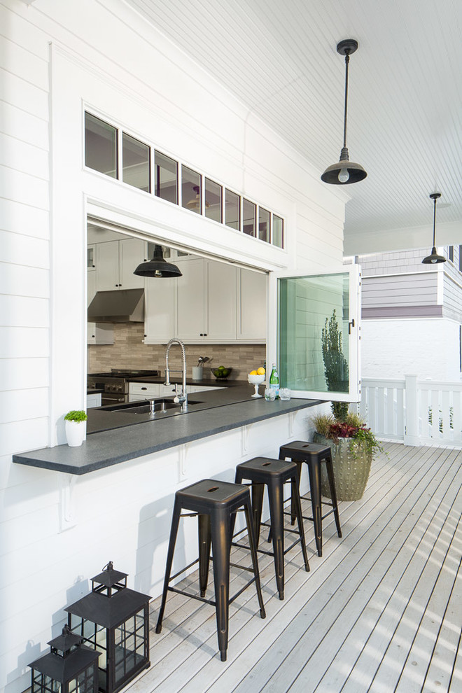 Example of a mid-sized transitional backyard deck design in Seattle with a roof extension