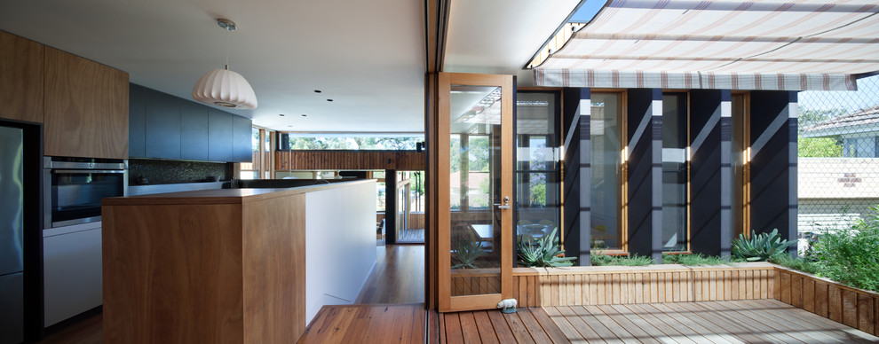 Пример оригинального дизайна: маленькая терраса на боковом дворе в современном стиле с растениями в контейнерах и козырьком для на участке и в саду