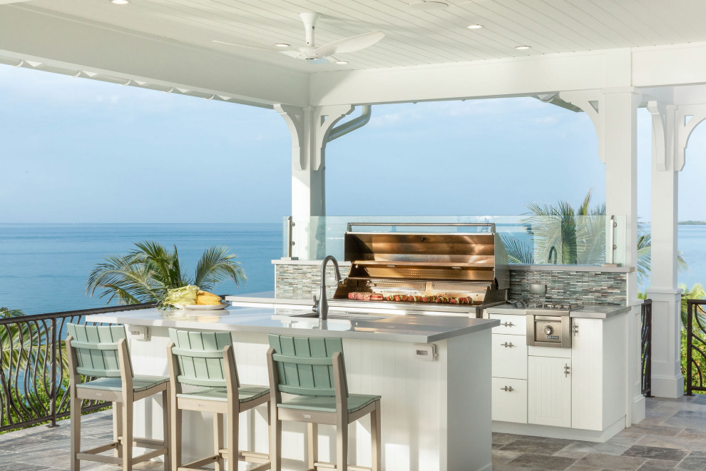 Example of a beach style outdoor kitchen deck design in Miami with a roof extension