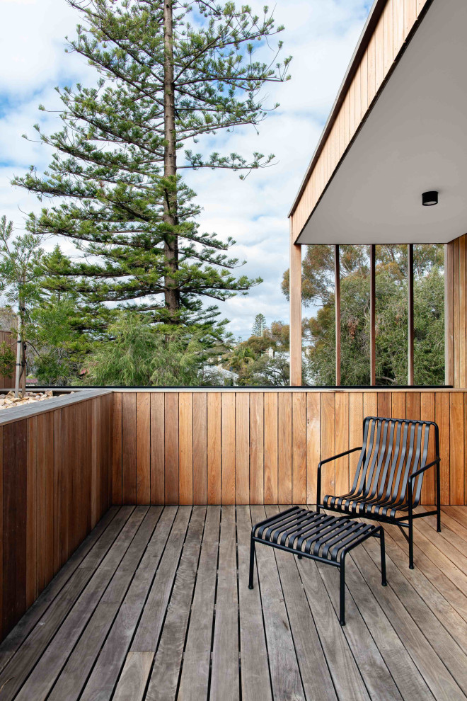 Inspiration pour une terrasse au premier étage urbaine avec une extension de toiture et un garde-corps en bois.