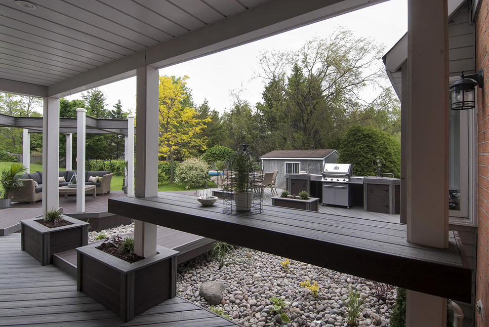 Ejemplo de terraza actual de tamaño medio en patio trasero con cocina exterior y pérgola
