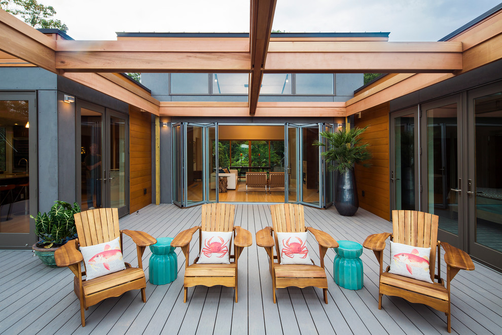 Cette photo montre une grande terrasse latérale tendance avec un foyer extérieur et une extension de toiture.