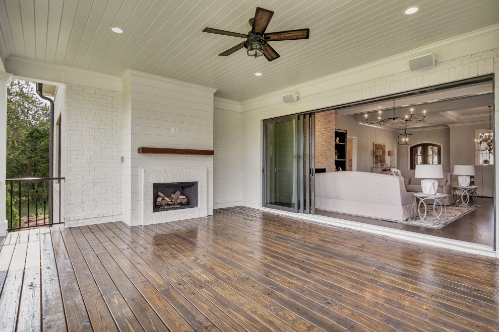 Large cottage backyard deck photo in Atlanta with a fireplace and a roof extension