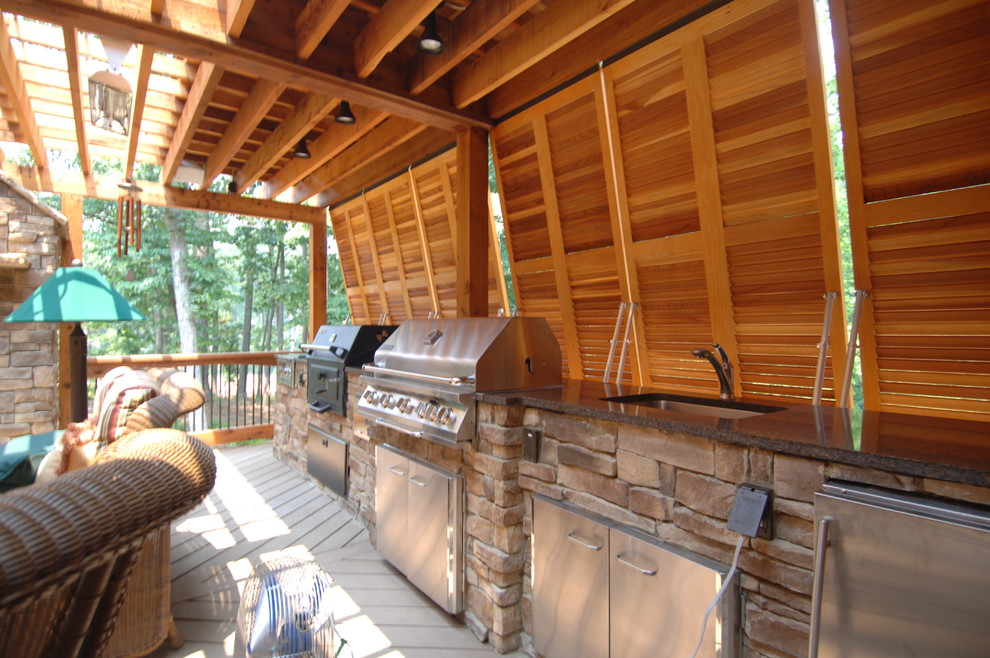 Huge mountain style backyard outdoor kitchen deck photo in Atlanta with a pergola