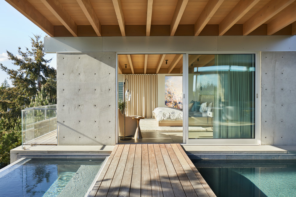 Inspiration pour une très grande terrasse latérale minimaliste avec une extension de toiture.