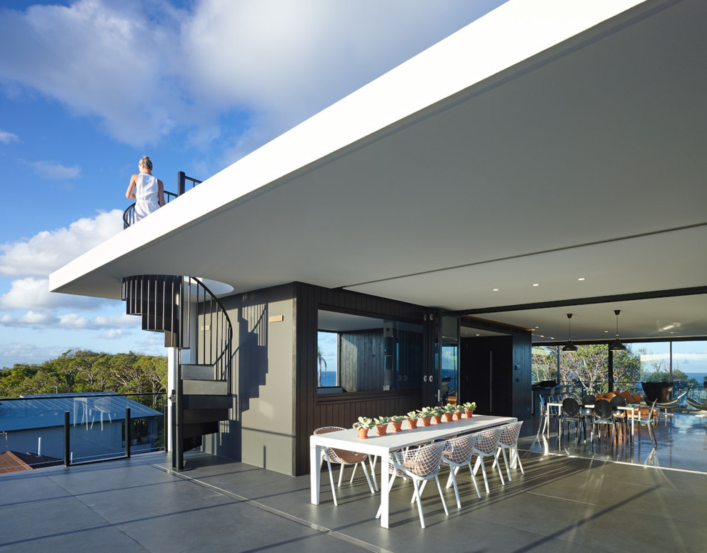Esempio di una terrazza contemporanea con un tetto a sbalzo