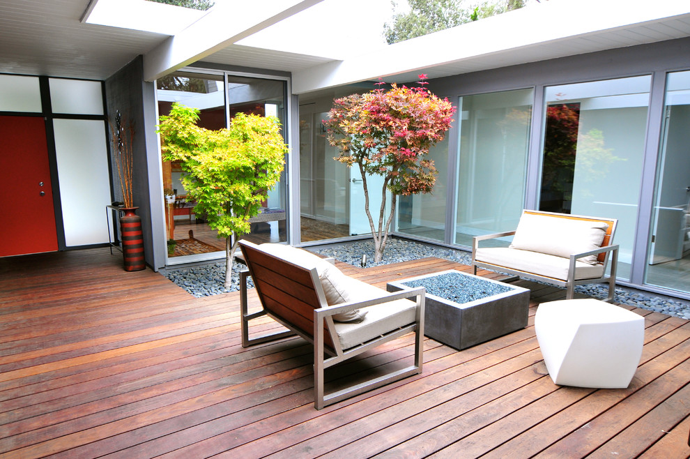 Example of a mid-sized 1960s courtyard deck design in San Francisco with no cover
