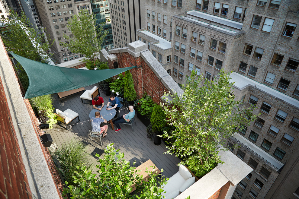 Design ideas for a small traditional roof terrace in New York with a potted garden and an awning.