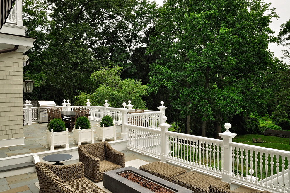 Inspiration pour une très grande terrasse arrière traditionnelle avec un foyer extérieur et un auvent.