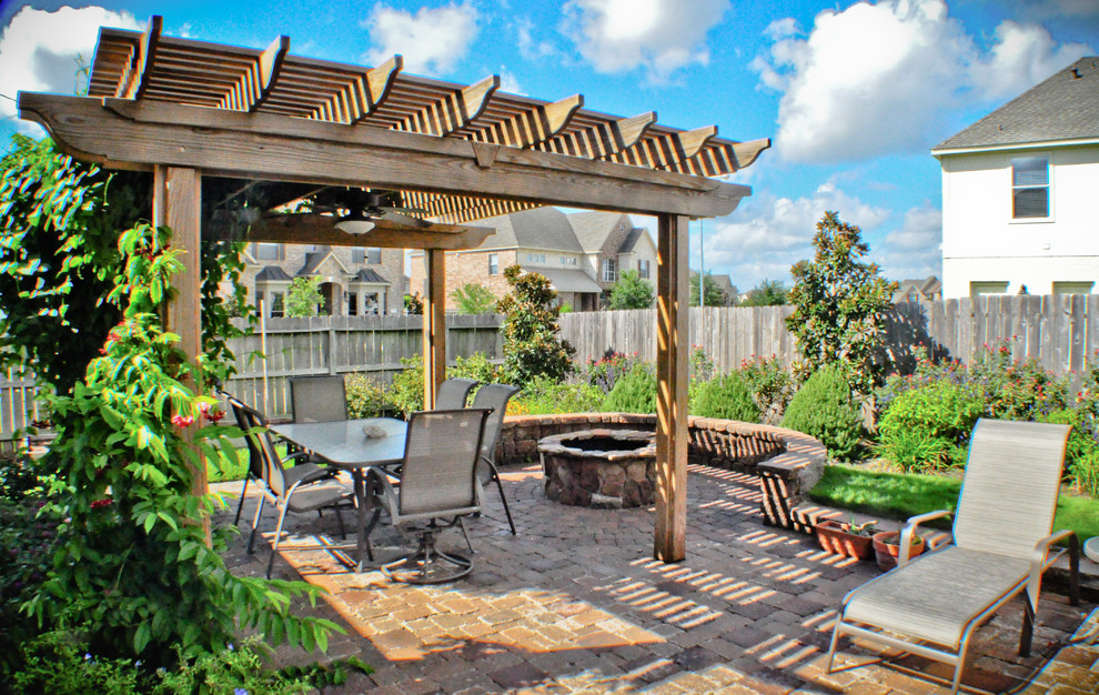 Inspiration for a medium sized mediterranean back terrace in Houston with a fire feature and a pergola.