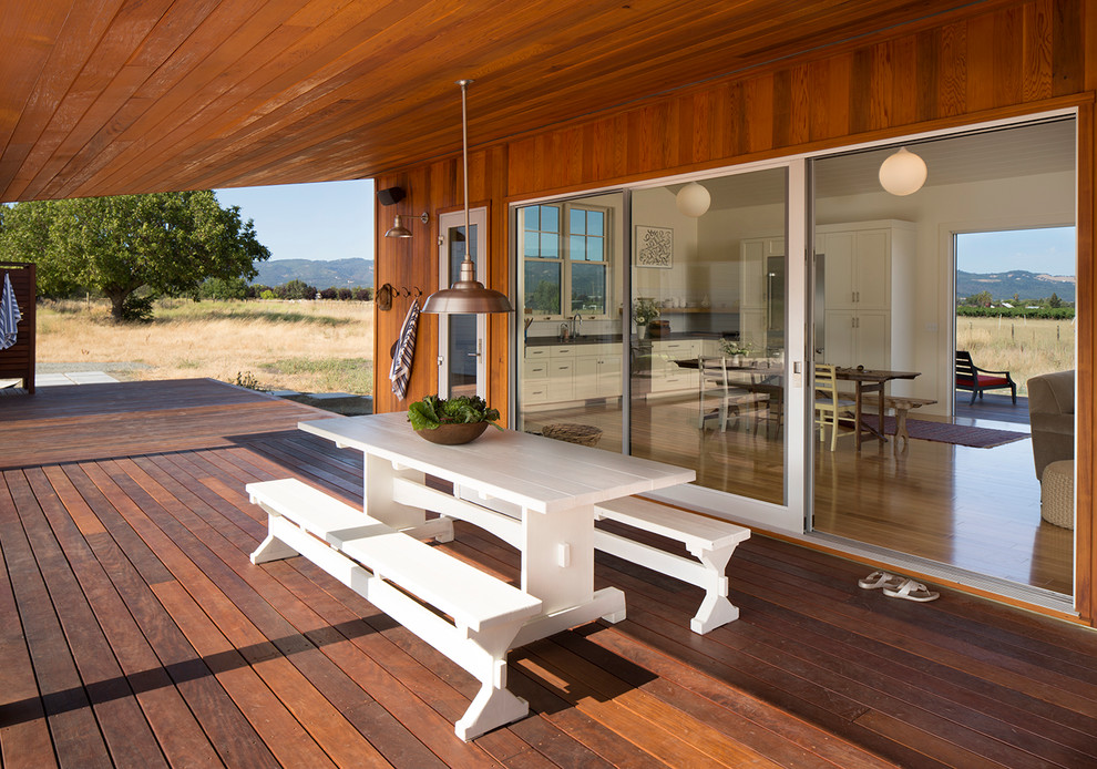 Diseño de terraza de estilo de casa de campo grande en patio trasero y anexo de casas