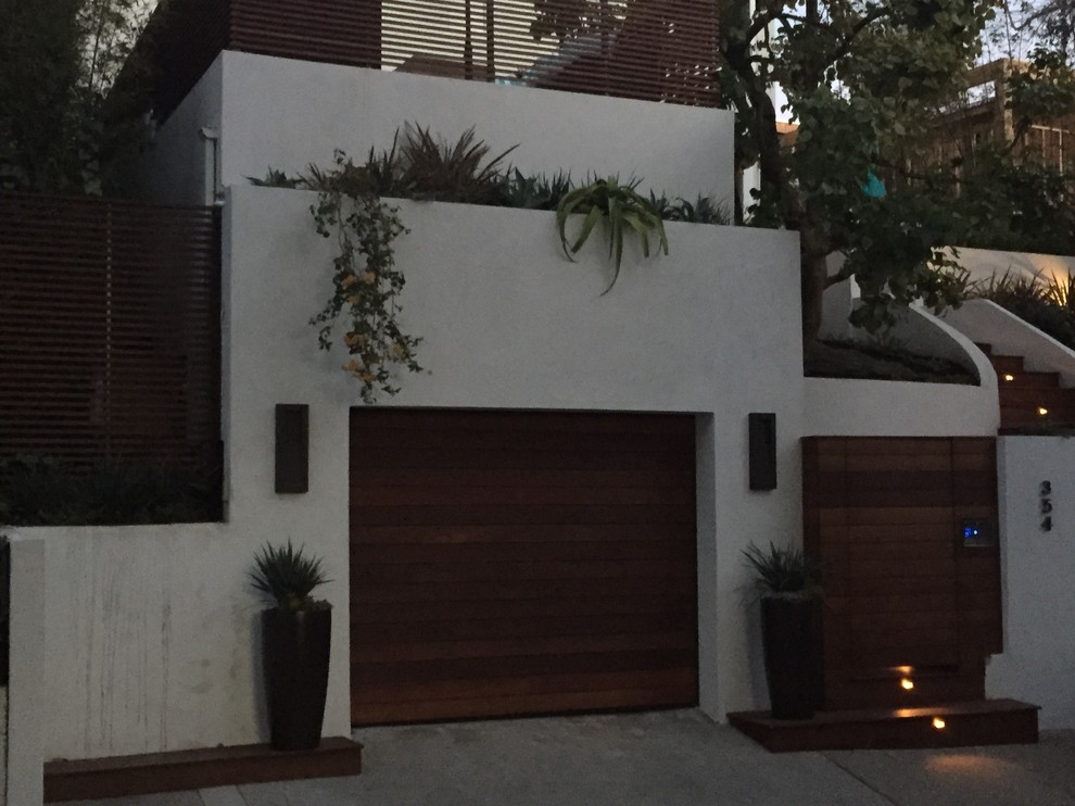 Photo of a large modern back terrace in Los Angeles with a roof extension.