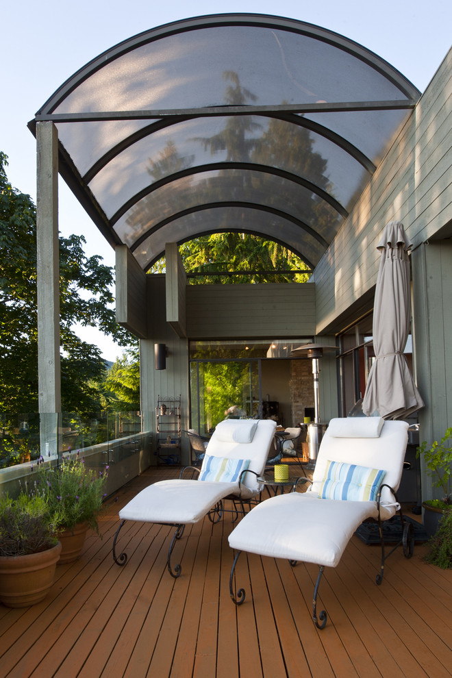 Example of a large minimalist side yard deck design in Vancouver with an awning