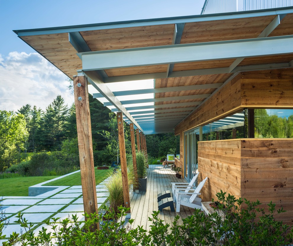 Exemple d'une terrasse avec des plantes en pots arrière scandinave avec une extension de toiture.