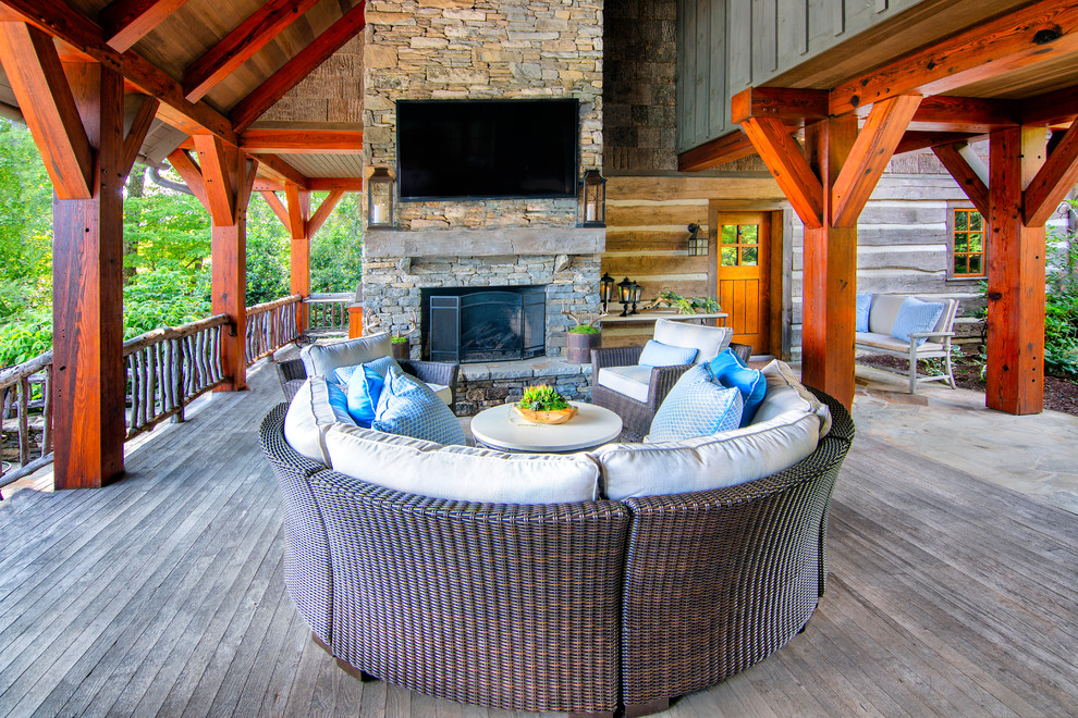 Deck - large rustic backyard deck idea in DC Metro with a fireplace and a roof extension