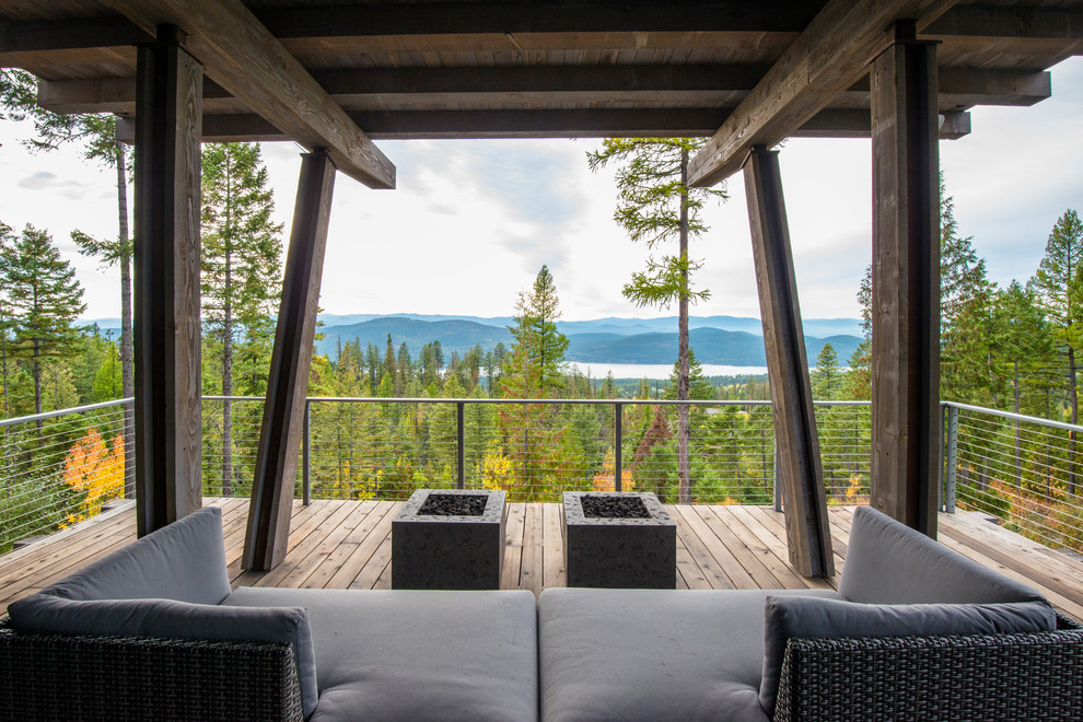 Cette photo montre une terrasse arrière montagne avec un foyer extérieur et une extension de toiture.