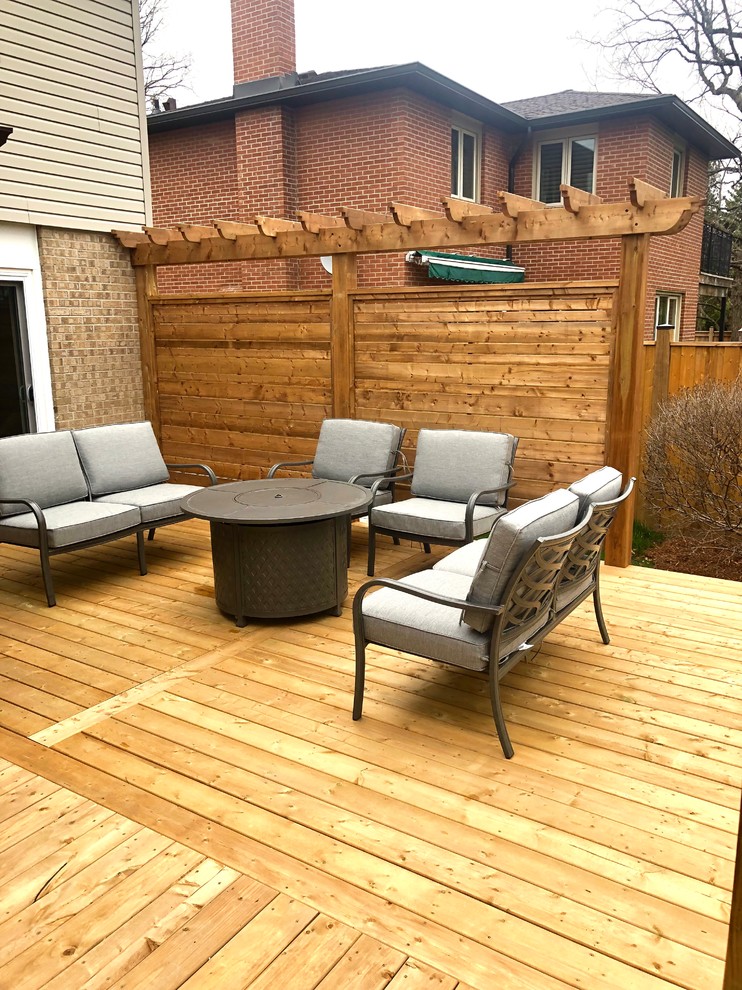 Deck - large traditional backyard deck idea in Toronto with a pergola