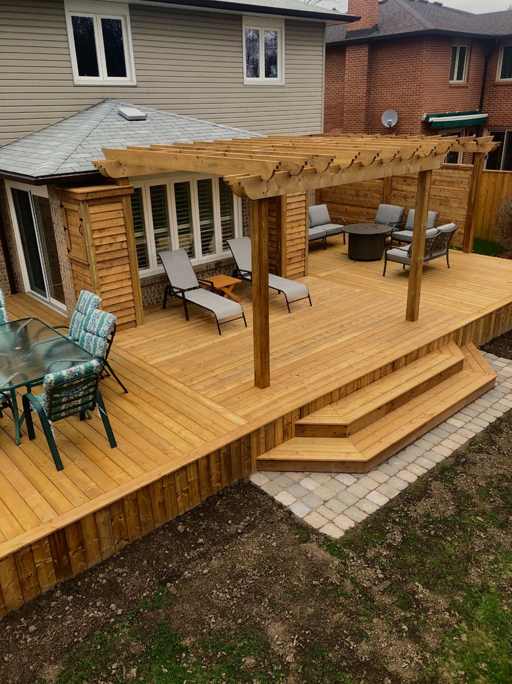 Large elegant backyard deck photo in Toronto with a pergola