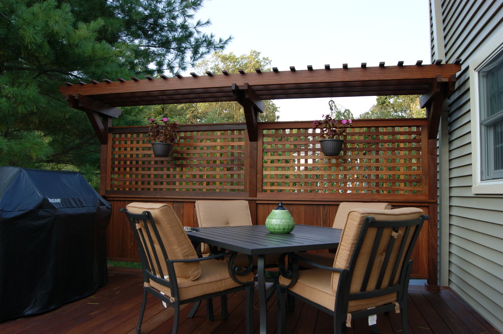 Deck - large traditional backyard deck idea in New York with a pergola