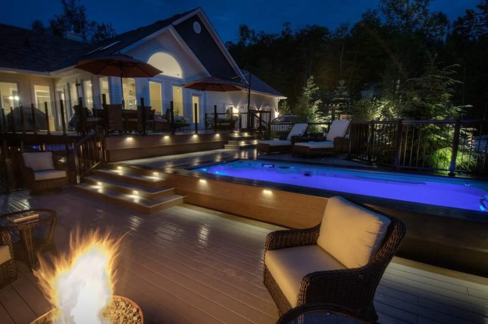 Photo of a large modern back terrace in Toronto with a fire feature and no cover.