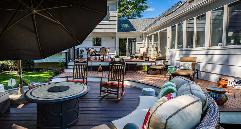 Example of a large classic backyard deck design in Newark with a fire pit and no cover