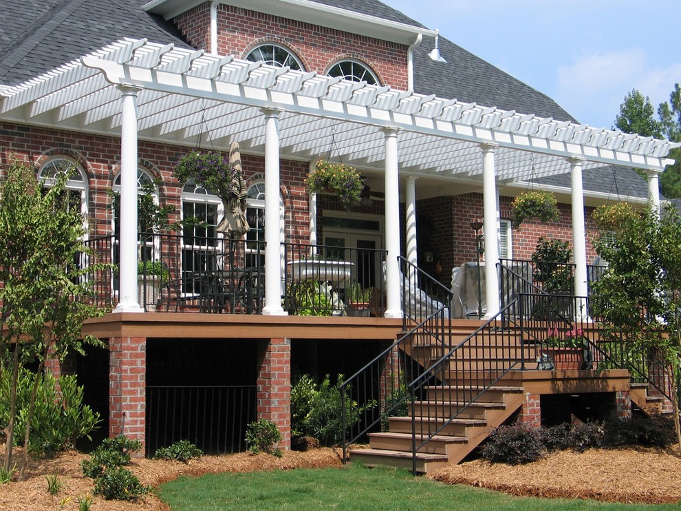 Deck - huge eclectic backyard deck idea in Nashville with a pergola