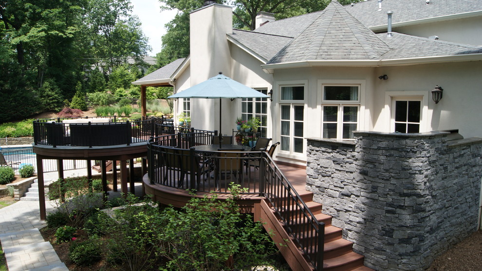 Cette photo montre une très grande terrasse arrière craftsman avec un foyer extérieur.