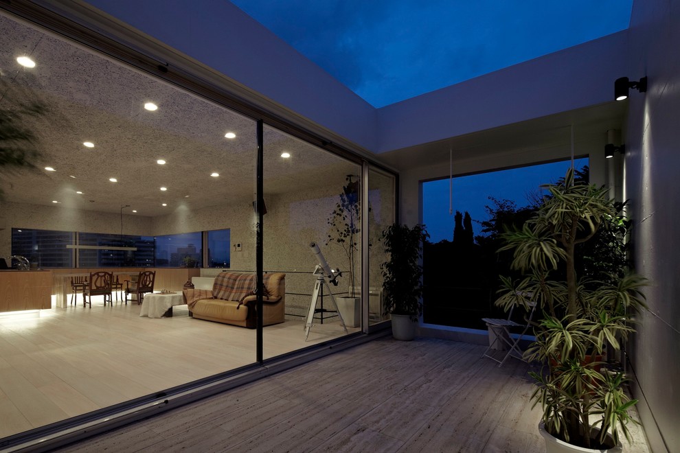 Exemple d'une terrasse tendance de taille moyenne avec une extension de toiture.