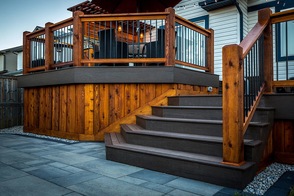 Photo of a large traditional back terrace in Calgary with an outdoor kitchen and a pergola.