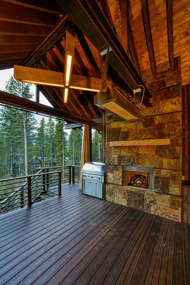 Exemple d'une grande terrasse arrière montagne avec une cuisine d'été et une extension de toiture.