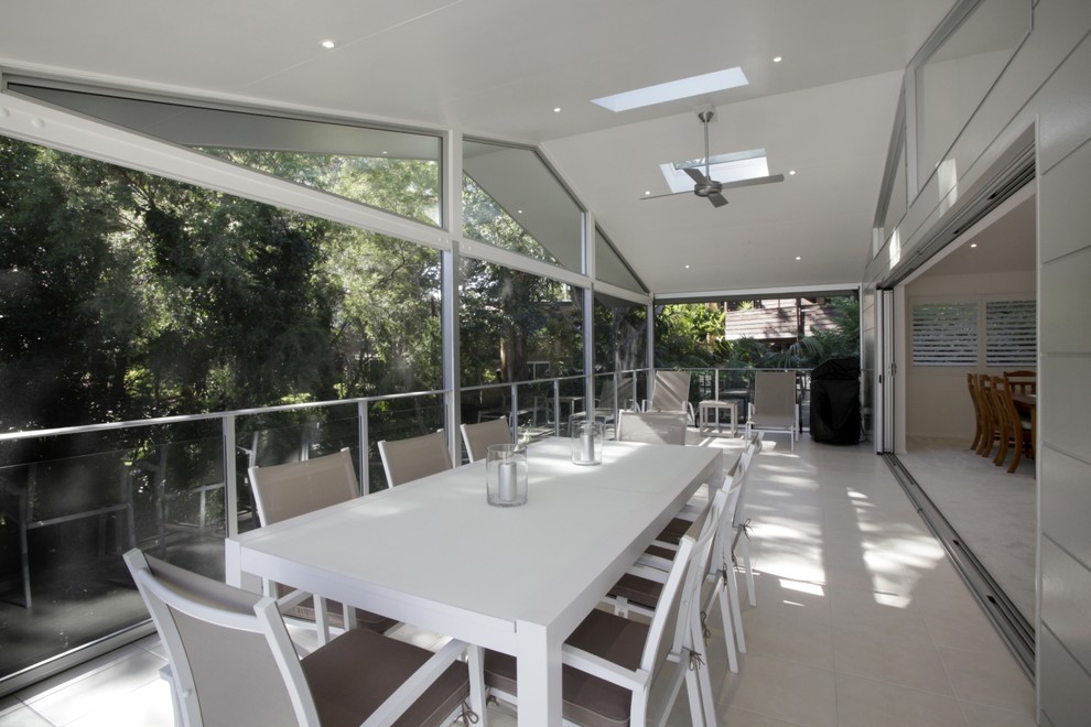 Inspiration pour une grande terrasse arrière minimaliste avec une extension de toiture.