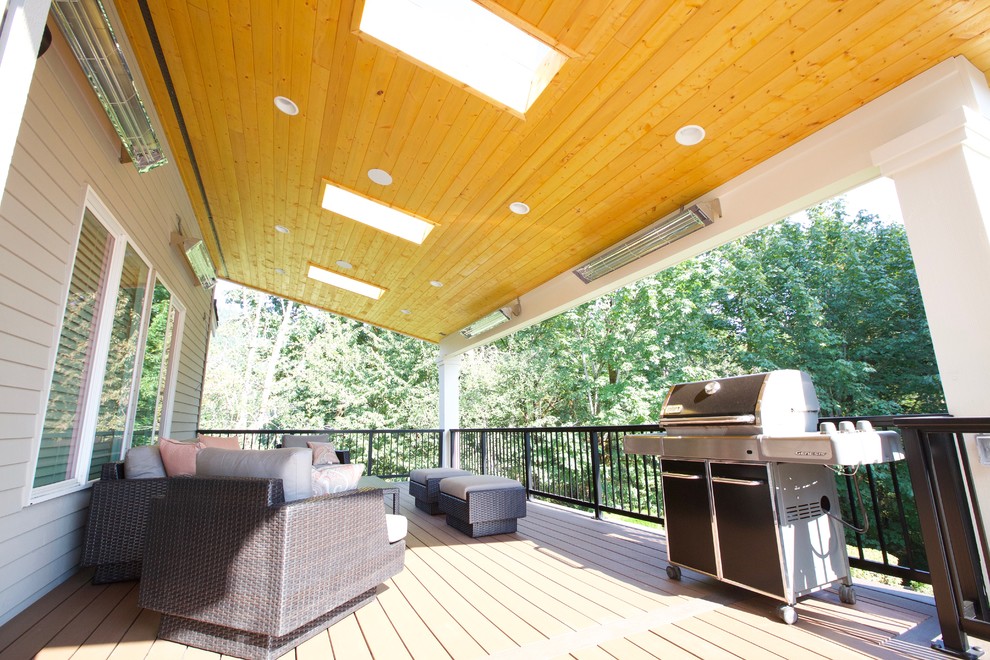 Réalisation d'une très grande terrasse arrière minimaliste avec un foyer extérieur et une extension de toiture.