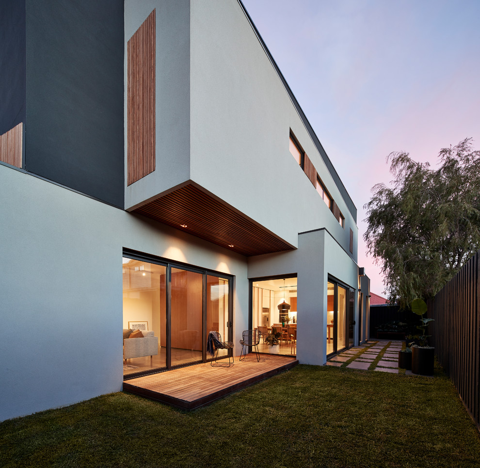 Cette image montre une terrasse latérale minimaliste avec une extension de toiture.