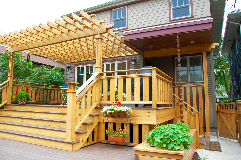 Ejemplo de terraza de estilo americano de tamaño medio en patio trasero con jardín de macetas y pérgola