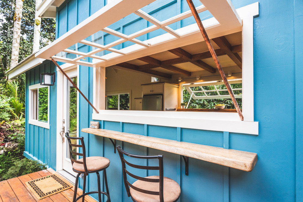 Aménagement d'une petite terrasse latérale bord de mer avec une cuisine d'été et un auvent.