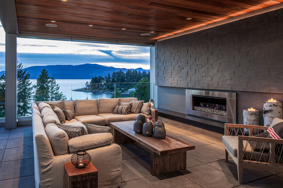 This is an example of a contemporary terrace in Vancouver with a fire feature and a roof extension.