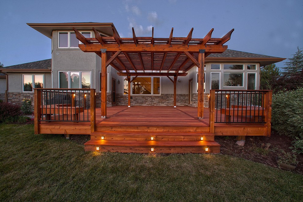 Elegant backyard deck photo in Denver with a pergola