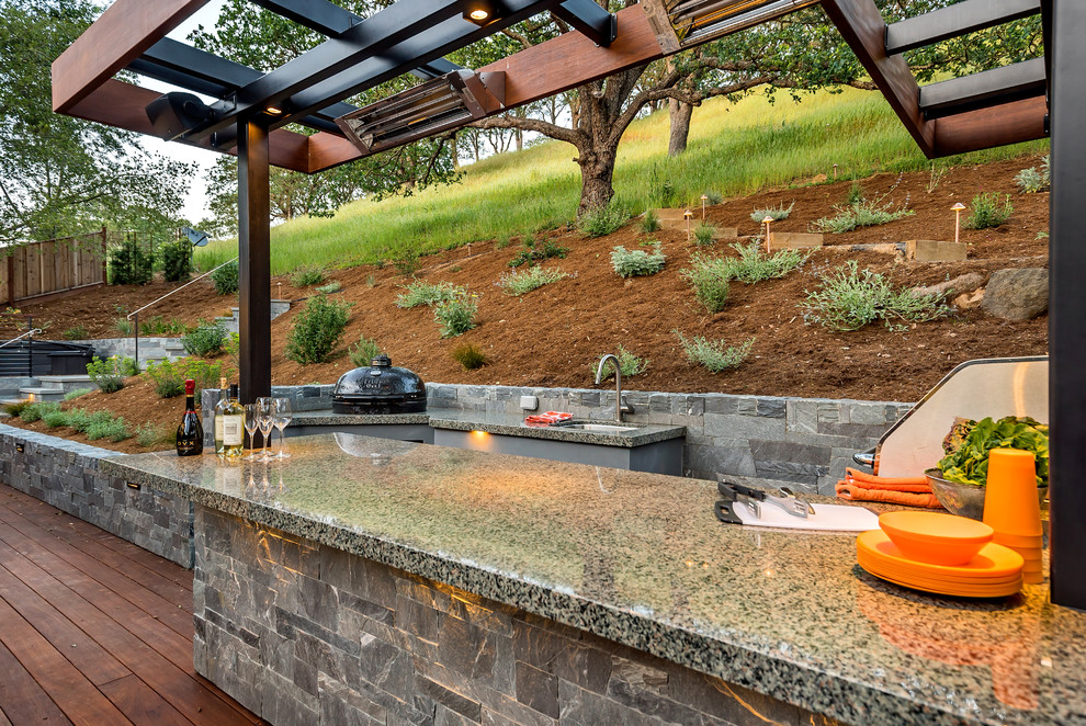 Cette image montre une grande terrasse arrière vintage avec une cuisine d'été et une pergola.