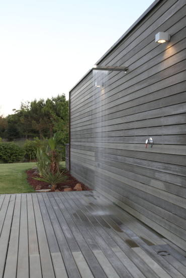 Cette image montre une grande terrasse arrière minimaliste avec un point d'eau et aucune couverture.