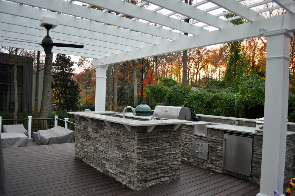 Diseño de terraza clásica grande en patio trasero con cocina exterior y pérgola