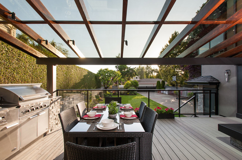 Example of a mid-sized trendy backyard deck design in Vancouver with a pergola