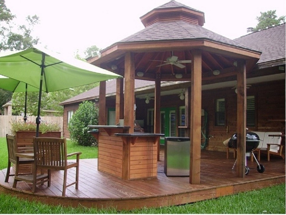 На фото: большая терраса на заднем дворе в стиле модернизм с летней кухней и навесом с