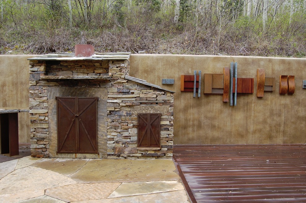 This is an example of a large rustic back terrace in Salt Lake City with a fire feature and no cover.