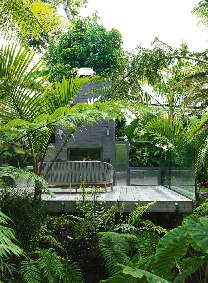 Ispirazione per una grande terrazza tropicale dietro casa con un caminetto